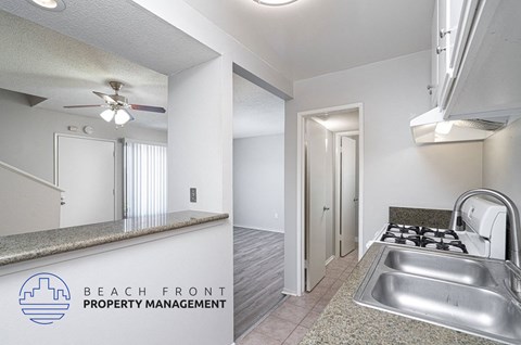 the kitchen and living room of an apartment with a stainless steel sink